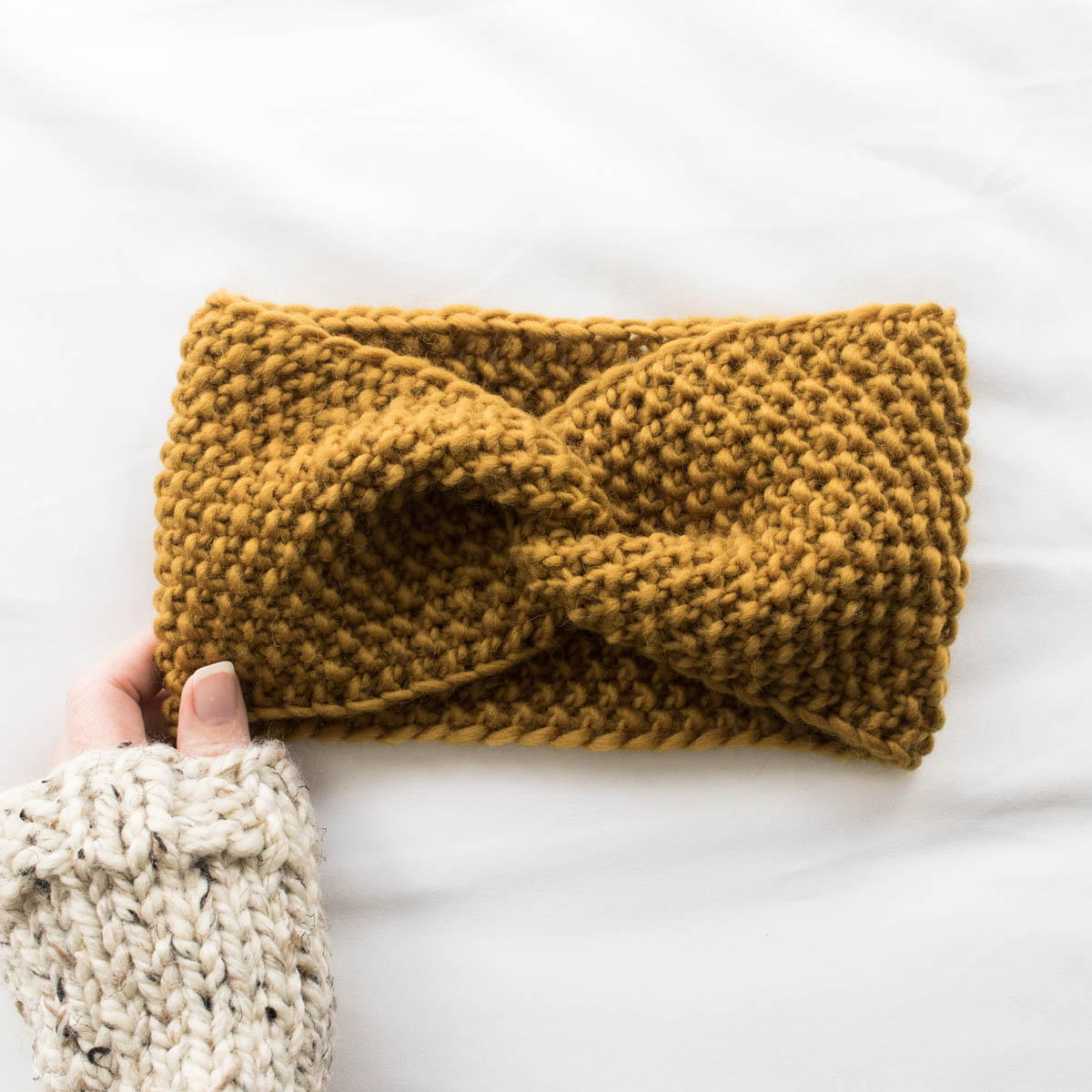 model wearing a chunky seed stitch headband with a messy bun