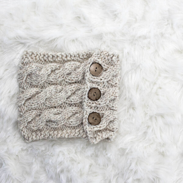 a button cowl displayed on a faux fur blanket