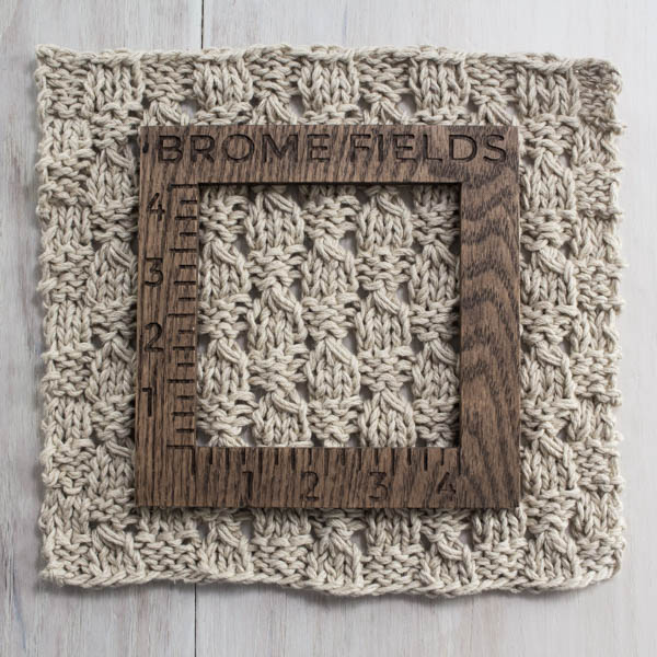 knitted swatch of a farmhouse placemat with a wood gauge