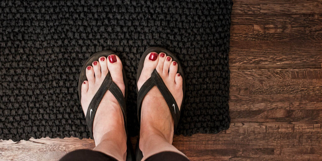 top down photo of women's feet on a t-shirt yarn rug