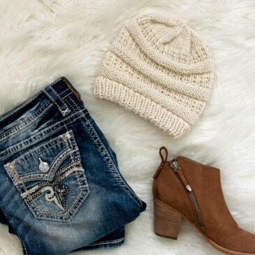 modern knit hat displayed on faux fur blanket with jeans & boots