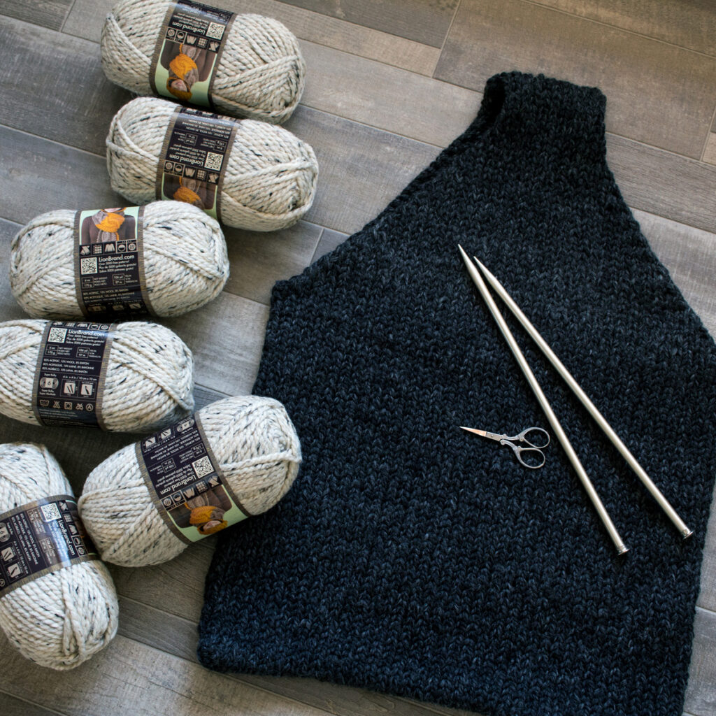 A Knitted Bag for Knitting laying on the floor with 6 skeins of bulky yarn