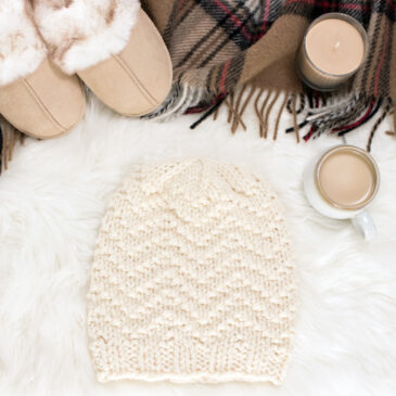 chevron knit hat displayed on faux fur blanket with a blanket and coffee