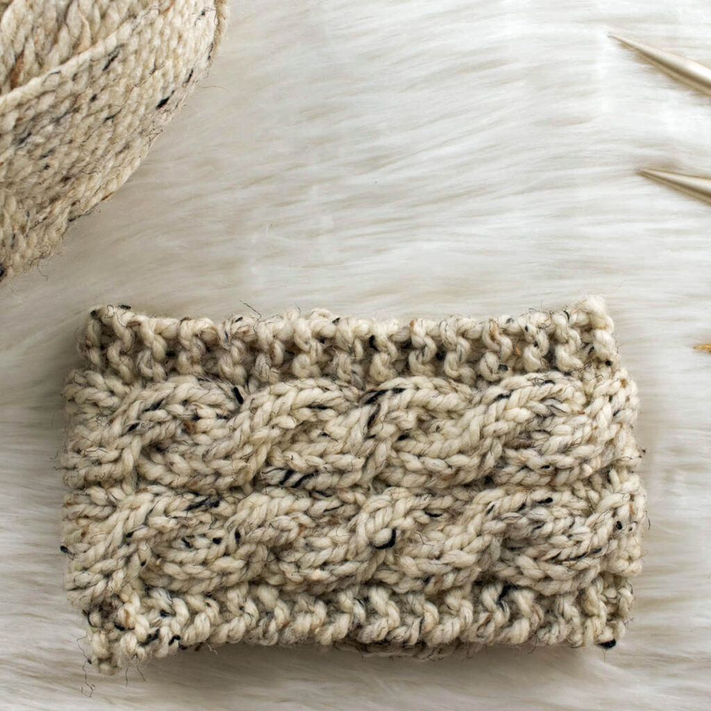 hand knitted cable headband on a faux fur blanket